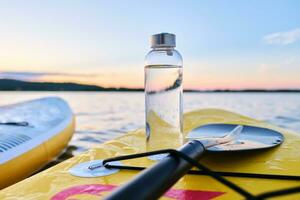Wasser Flasche auf ein Gelb Paddel Boot. foto