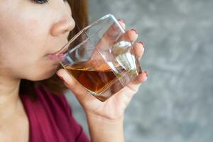 betont asiatisch Frau Trinken Alkohol Hand halten Whiskey Glas ,Alkoholismus Konzept foto