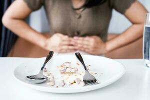 Frau haben Erdnuss Allergie Reaktion mit Verdauungs- Probleme Bauch Krämpfe, Übelkeit und Durchfall nach Essen Mahlzeit foto