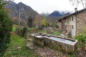 alte Brunnen in einem Dorf der italienischen Alpen foto