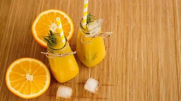 Orangensaftflaschen und Papierstrohhalme. eisiges Getränk an einem sonnigen Tag foto