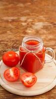 Glas Tomatensaft auf Holztisch. frischer Tomatensaft foto