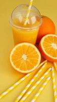 Orangensaft in Fast Food geschlossene Tasse mit Tube auf Gelb