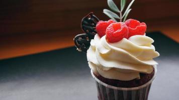 leckere Himbeer-Cupcakes auf dunklem Hintergrund foto