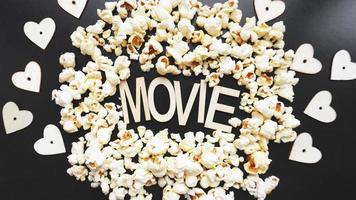 Popcorn auf schwarzem Hintergrund. einen Film mit Popcorn anschauen foto
