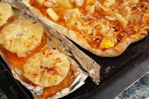 Hähnchenfilet mit Ananas auf Folie und hausgemachter hawaiianischer Pizza foto
