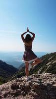junge Frau, die in einer Yoga-Pose steht - Montserrat-Berge foto