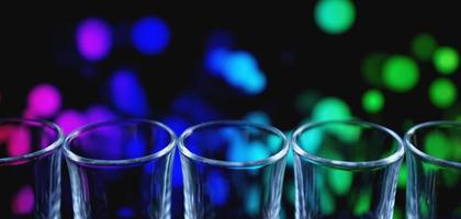 Reihe von sauberen, glänzenden Gläsern auf einer Bartheke in einem Nachtclub foto