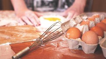 professionelle Bäckerin, die Teig mit Eiern und Mehl kocht foto