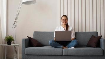 Frau, die von zu Hause oder vom Studenten am Laptop arbeitet foto