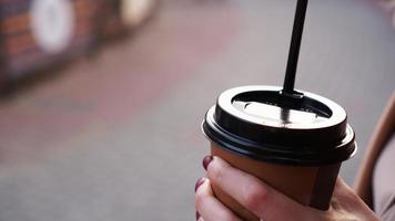 Frauenhand hält draußen eine Tasse Kaffee foto