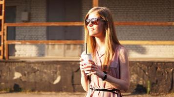 junge Frau mit einer Tasse Limonade draußen