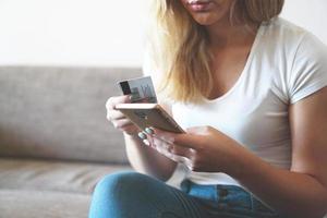 Online-Zahlung, Frauenhände, die Smartphone halten und Kreditkarte verwenden foto