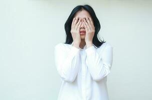 Porträt von müde asiatisch Geschäft Frau gesetzt von Unternehmen Konkurs Abdeckung Gesicht mit Hände tragen Weiß Hemd formal passen Stehen isoliert Hintergrund foto