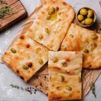 golden gebacken traditionell Italienisch Focaccia Brot mit Grün Oliven foto