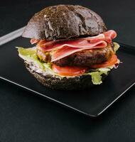 modern schwarz Burger mit Prosciutto Schinken foto