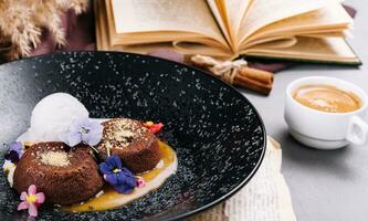 Schokolade Lava Kuchen mit Eis Sahne serviert auf Teller gegen Tasse von Kaffee foto