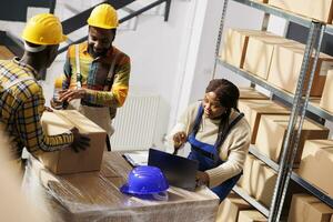 Warenhaus Manager Überprüfung Aufträge aufführen und koordinieren Pakete Verpackung Verfahren. afrikanisch amerikanisch Frau Supervisor mit Laptop steuern Fracht Karton Kisten Abdichtung und Versand foto