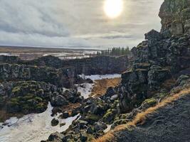 steil Fluss Senke mit enorm Felsen im Dingvellir National Park, Zuhause zu hervorragend Fauna und Flora im Island. schön isländisch felsig Klippen Bildung fest Berg Wände, Wildnis Landschaft. foto