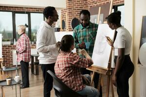 jung Menschen freunde nehmen Zeichnung Klasse im Kunst Studio, Teilnahme kreativ Werkstatt zusammen. Gruppe von afrikanisch amerikanisch Studenten Männer und Frauen Hören zu Lehrer, Lernen Skizzierung Techniken foto