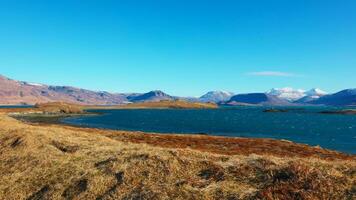 spektakulär See und schneebedeckt Berge im Island, schön sauber isländisch Natur. fest Wasser Stelle mit Hügel und Felder Erstellen skandinavisch Panorama- Sicht, nordisch Landschaft. Handheld Schuss. foto