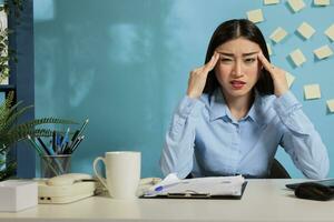 abgelenkt Frau von Arbeit Gefühl Schlecht Sitzung beim Computer betont hat Angst Attacke im das Arbeitsplatz. gestört weiblich Mitarbeiter leidet von Kopfschmerzen oder Schwindel im das Büro. foto