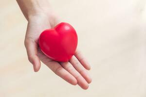 rot Herz Liebe Zeichen im Arzt Hand Übung Ball mit Kopieren Raum zum Welt Herz Gesundheit Tag Tag, Welt Hypertonie Herz Attacke Tag. foto