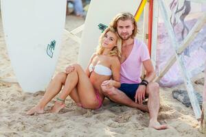 schön blond Frau und gut aussehend Mann , posieren auf das tropisch Sommer- Strand Surfer Hintergrund. foto