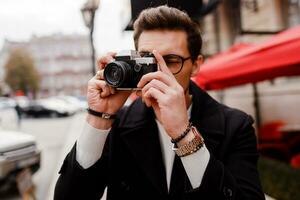 stilvoll Mann mit Fotoapparat Herstellung Fotos im europäisch Stadt.
