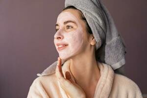 Haut Pflege. Frau mit Maske zu ihr Gesicht. das Mädchen nimmt Pflege von ölig Haut. kosmetisch Verfahren. foto