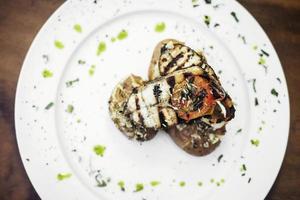 gegrillter Gourmetgrill frischer Fisch mit Bratkartoffeln Kräutern Olivenöl Knoblauchsauce foto