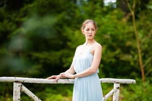 schöne junge Frau in einem langen blauen Kleid foto