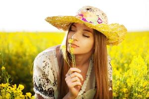 glückliches Mädchen genießt den Geruch einer Blume foto
