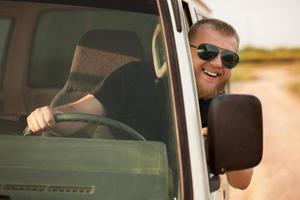 fröhlicher Fahrer hinter dem Lenkrad seines Autos foto