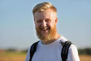 fröhlicher Mann mit Rucksack auf dem Rücken foto