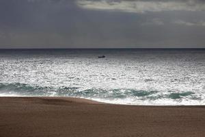 Landschaft mit einem kleinen Boot im Ozean foto