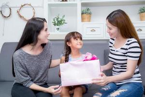 glückliche familie, mutter und tochter geben geschenkbox mit tochter. foto