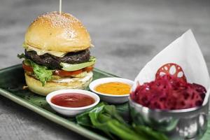 modernes Fusion Beef Burger Set mit Lotus Chips Ketchup und scharfen Chilisaucen foto