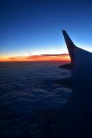 mysteriös Sonnenuntergang mit Wolken von das Flugzeug Fenster mit foto