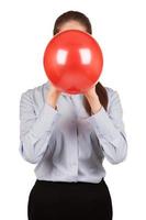 Mädchen in einem grauen Hemd hält einen aufgeblasenen Ballon foto