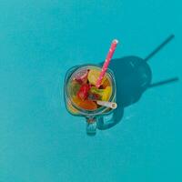 modisch Sommer- Cocktail gemacht von bunt gummiartig Süßigkeiten auf Licht Blau Hintergrund. minimal kreativ Idee. Natur Strand Konzept. foto