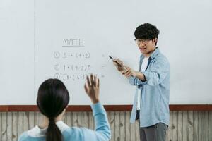 asiatischer männlicher lehrer, der schüler im klassenzimmer unterrichtet foto