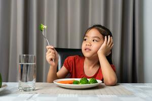 wenig süß Kind Mädchen ablehnen zu Essen gesund Gemüse. Kinder tun nicht mögen zu Essen Gemüse. foto