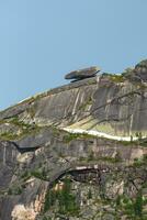 fallen groß Felsbrocken auf das Kante von das Abgrund. Mittag Sicht, Western Sayan. natürlich Park ergaki. krasnojarsk Region. Vertikale Sicht. foto