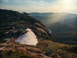 Schichten von Berge beim Sonnenuntergang. Sanft Rosa Sonnenuntergang im Berg Landschaft. tolle Rosa Sonnenuntergang mit ein Silhouette von Berge. fallen groß Felsbrocken auf das Kante von das Abgrund. natürlich Park ergaki. foto