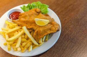 knusprig Schnitzel mit Französisch Fritten und Ketchup foto