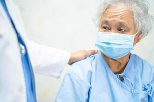 Asiatische Seniorin Patientenwarnmaske schützt das Covid-19-Coronavirus foto