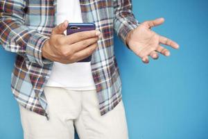 Nahaufnahme der Hand des jungen Mannes unter Verwendung des Smartphones foto