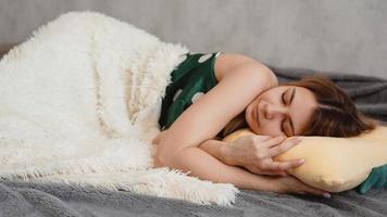 schönes junges Mädchen in einem grünen Nachthemd schläft auf einem gelben Kissen