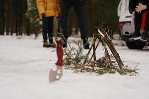 Touristenmesser und Lagerfeuer im Winterwald. foto